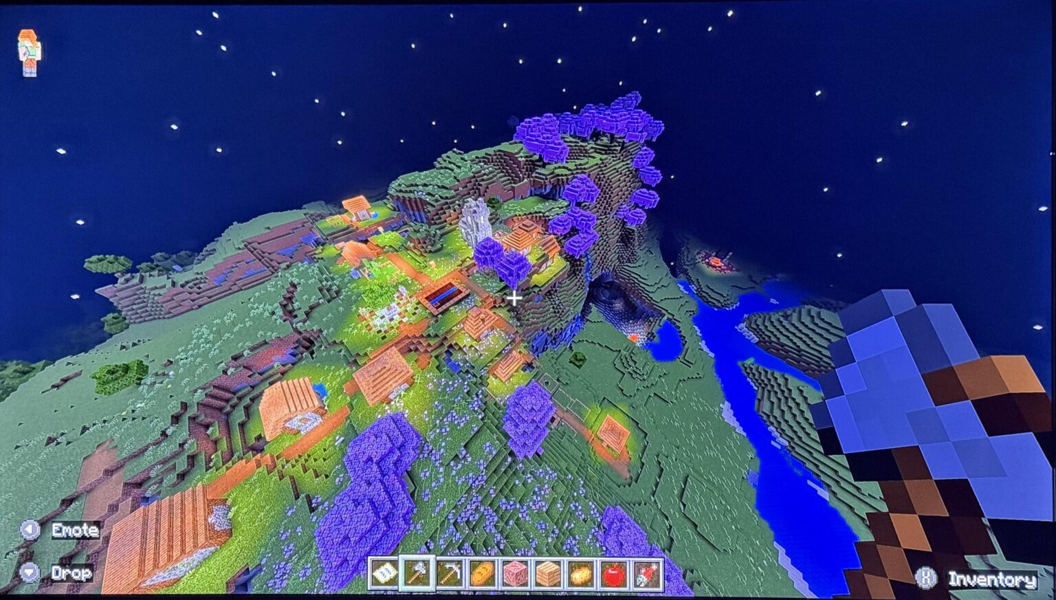 巨大な渓谷/洞窟と廃墟の門の隣にある桜の木立の村