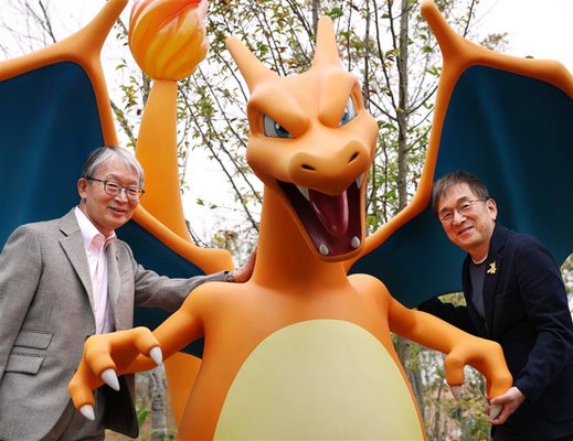 迫力満点のポケモン「リザードン」と石原社長（右）、山口社長