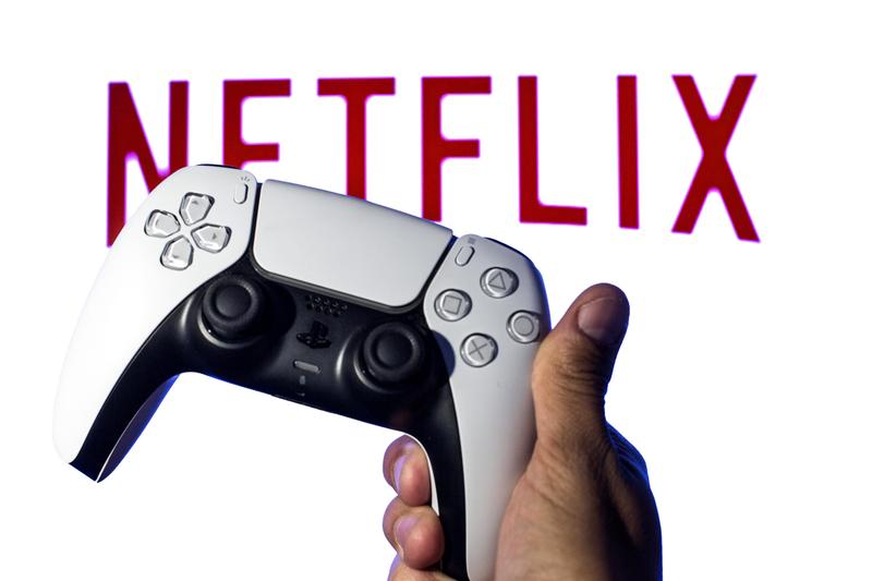 A game controller is pictured in front of the Netflix logo.